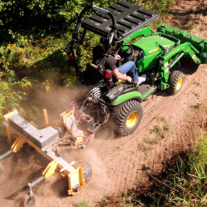 Nortec Raptor Compact Power Rake on Dirt Trail behind John Deere 1025R